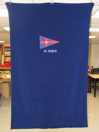 An appliqued burgee an embroidered boat name on a fleece berth blanket.